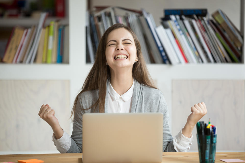 Excited female student feels euphoric celebrating online win success achievement result, young woman happy about good email news, motivated by great offer or new opportunity, passed exam, got a job