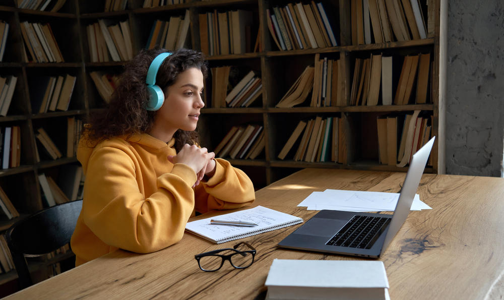 person studying on a laptop in a library 