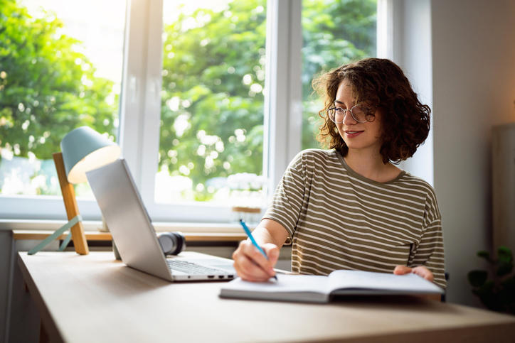 Woman studying for the CMA Exam and taking notes