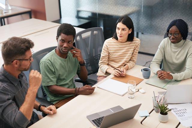 Two men and two women of different ethnicities discussing microaggressions in the workplace