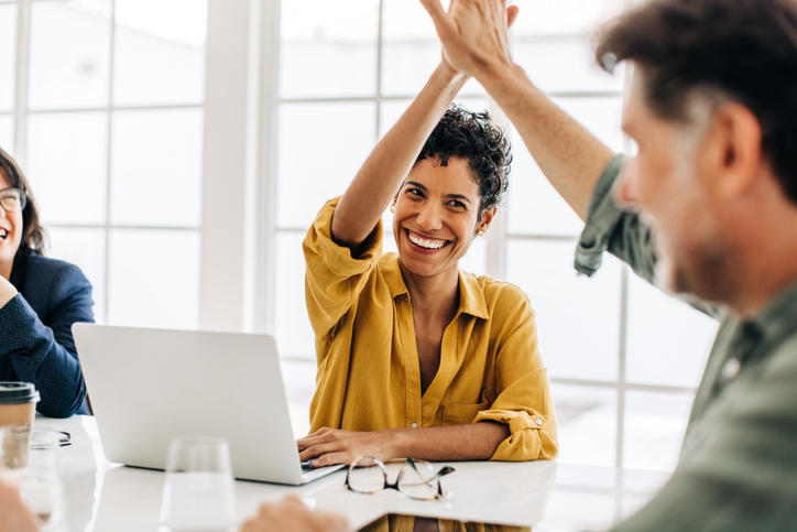 Woman high fiving a co-worker celebrating passing the SEE Exam