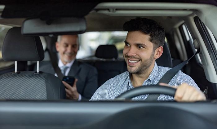 Young male uber driver with passenger in back seat (representing preparing independent contractor taxes