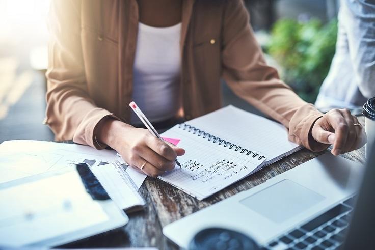 Woman writing down Accounting career goals in a notebook