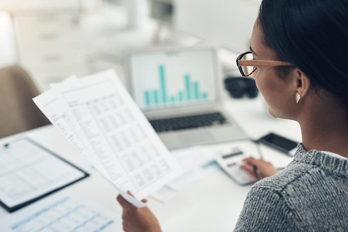 Woman wearing glasses is a Certified Internal Auditor analyzing financial statement