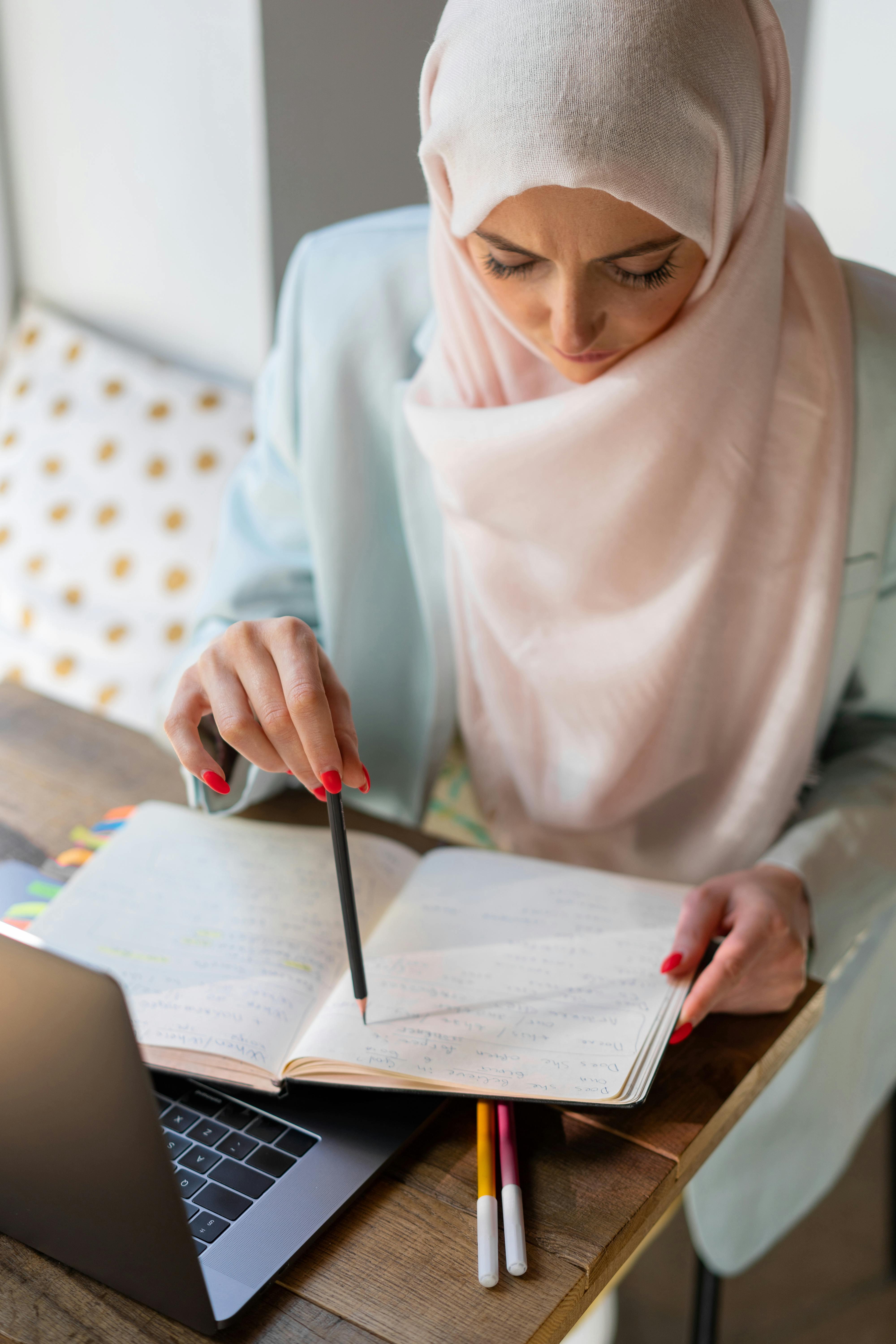 woman's hands holding notebook with notes for studying for the CIA Auditor Exam Guide 